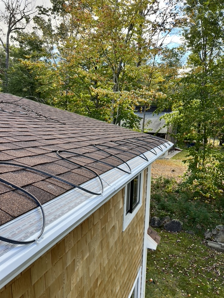 Heat cable installed in gutter channel and along roof shingles